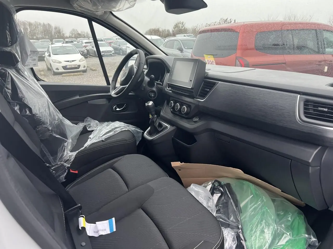 Intérieur côté conducteur du Nissan Primastar blanc 2025, montrant le tableau de bord et la console centrale avec boîte manuelle.