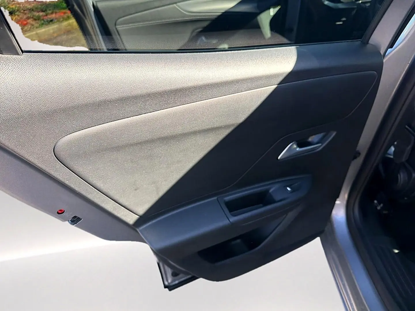 Vue rapprochée de la porte arrière droite grise de l’Opel Mokka Electric 156 gs avec panneau intérieur noir.
