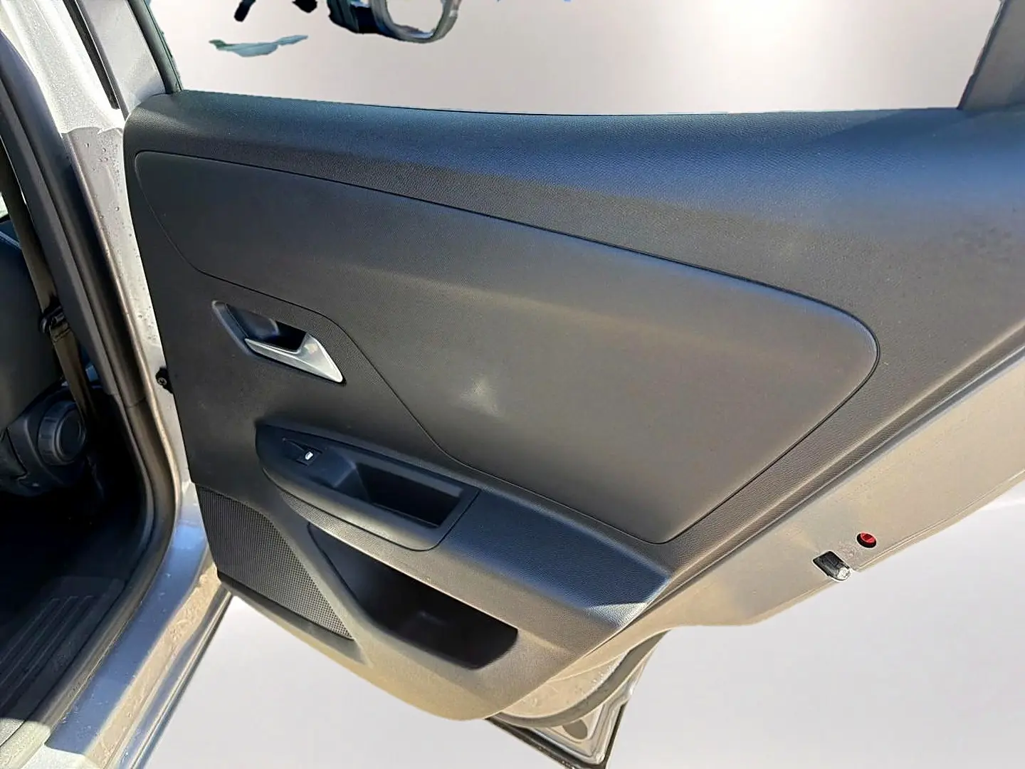 Vue rapprochée de la porte avant gauche grise de l’Opel Mokka Electric 156 gs avec poignée argentée et commande de vitre.
