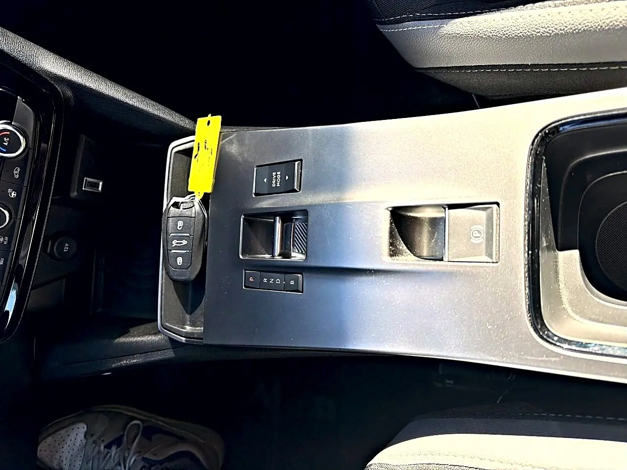 Vue plongeante sur la console centrale grise de l'Opel Mokka Electric 156 GS avec clé et commandes de boîte automatique.
