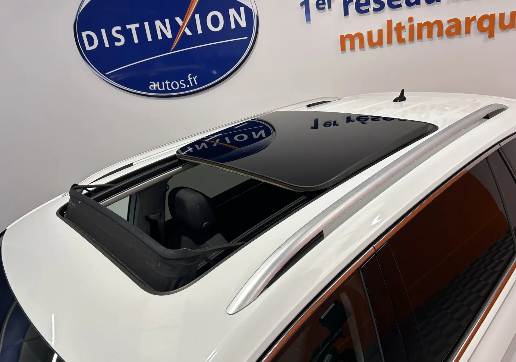 Toit ouvrant panoramique ouvert sur un Volkswagen Tiguan Allspace blanc, vue plongeante côté gauche arrière.