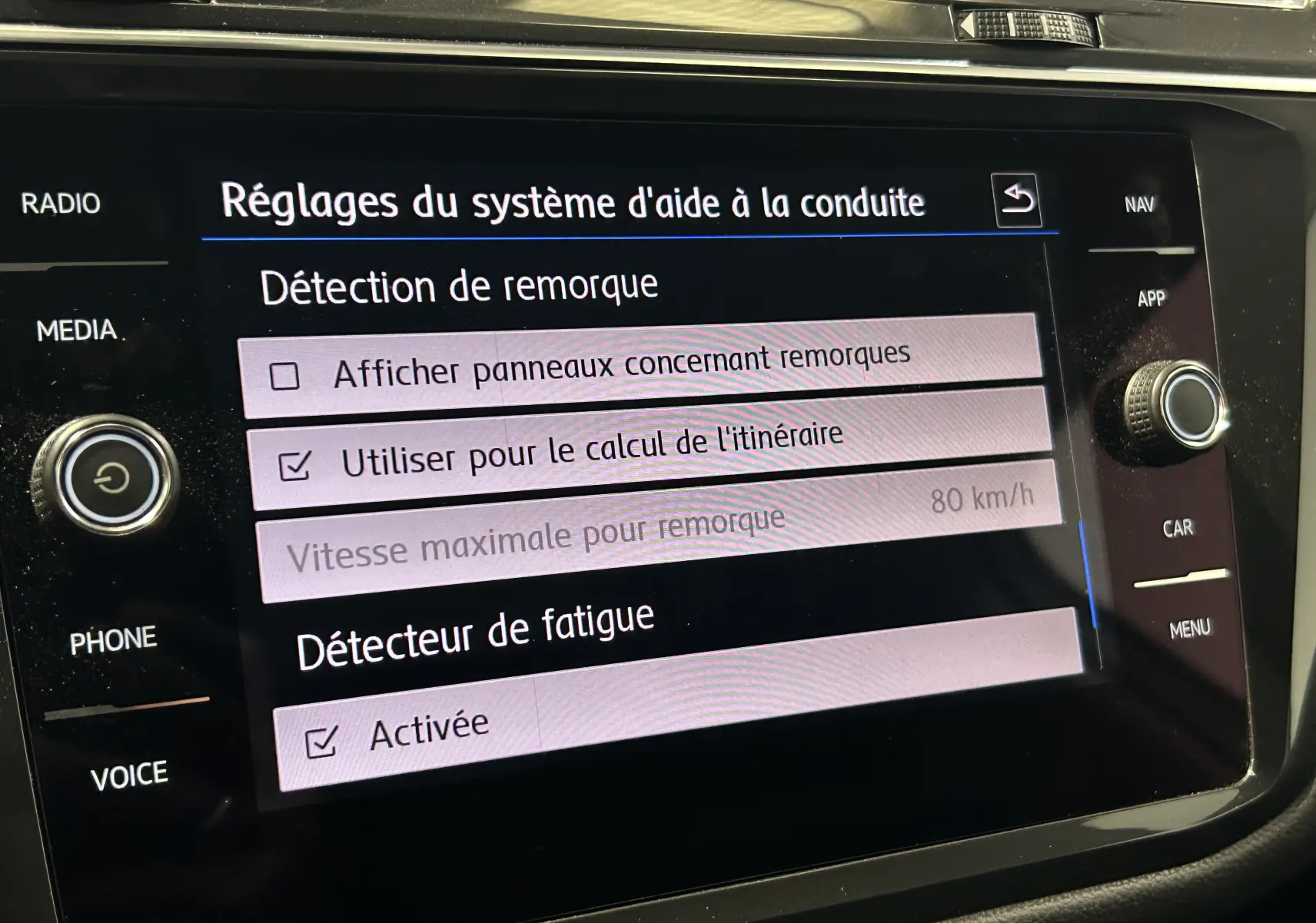 Écran tactile du système d'aide à la conduite du Volkswagen Tiguan Allspace affichant les réglages de détection de remorque et détecteur de fatigue activé.