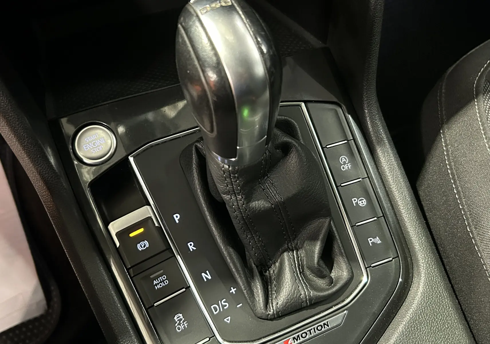 Le levier de vitesses DSG et les commandes autour dans l'habitacle noir du Volkswagen Tiguan Allspace blanc.