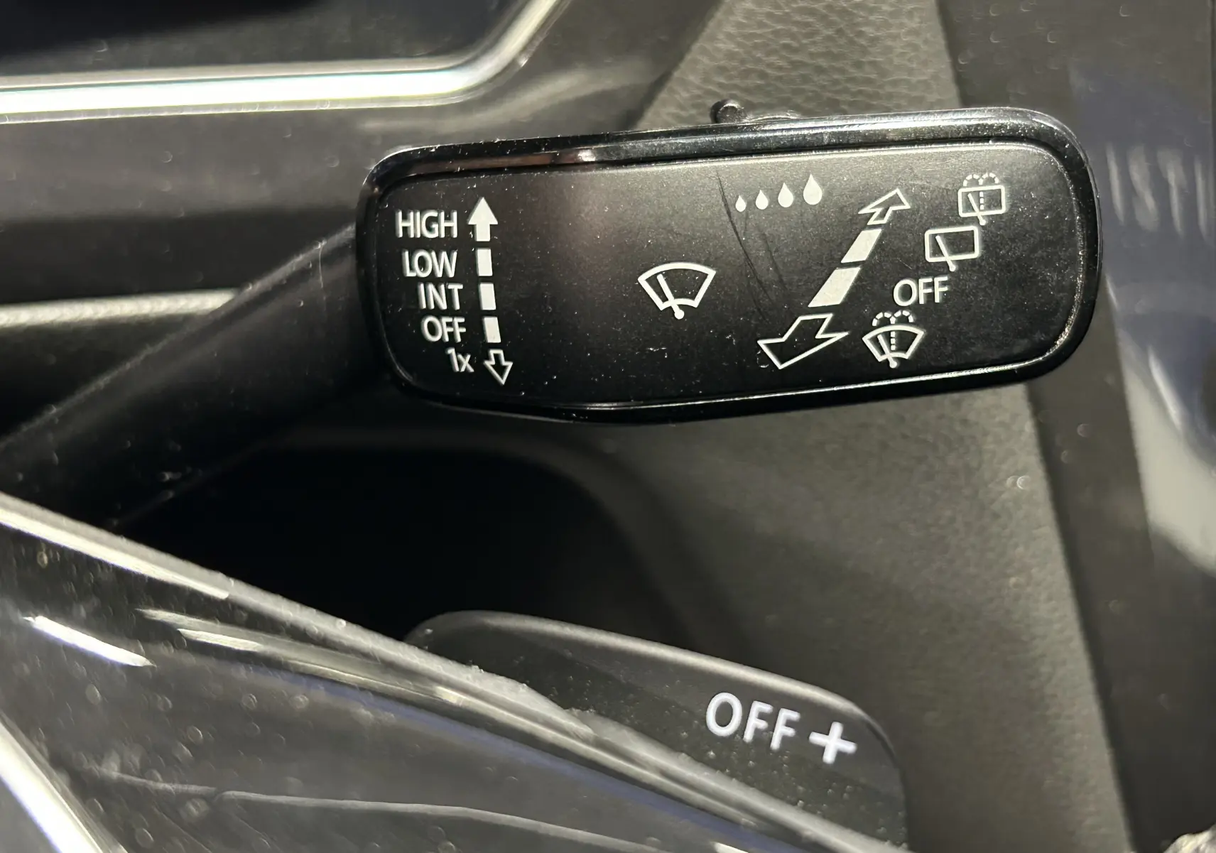 Gros plan sur la commande des essuie-glaces du Volkswagen Tiguan Allspace blanc, détails des réglages visibles.