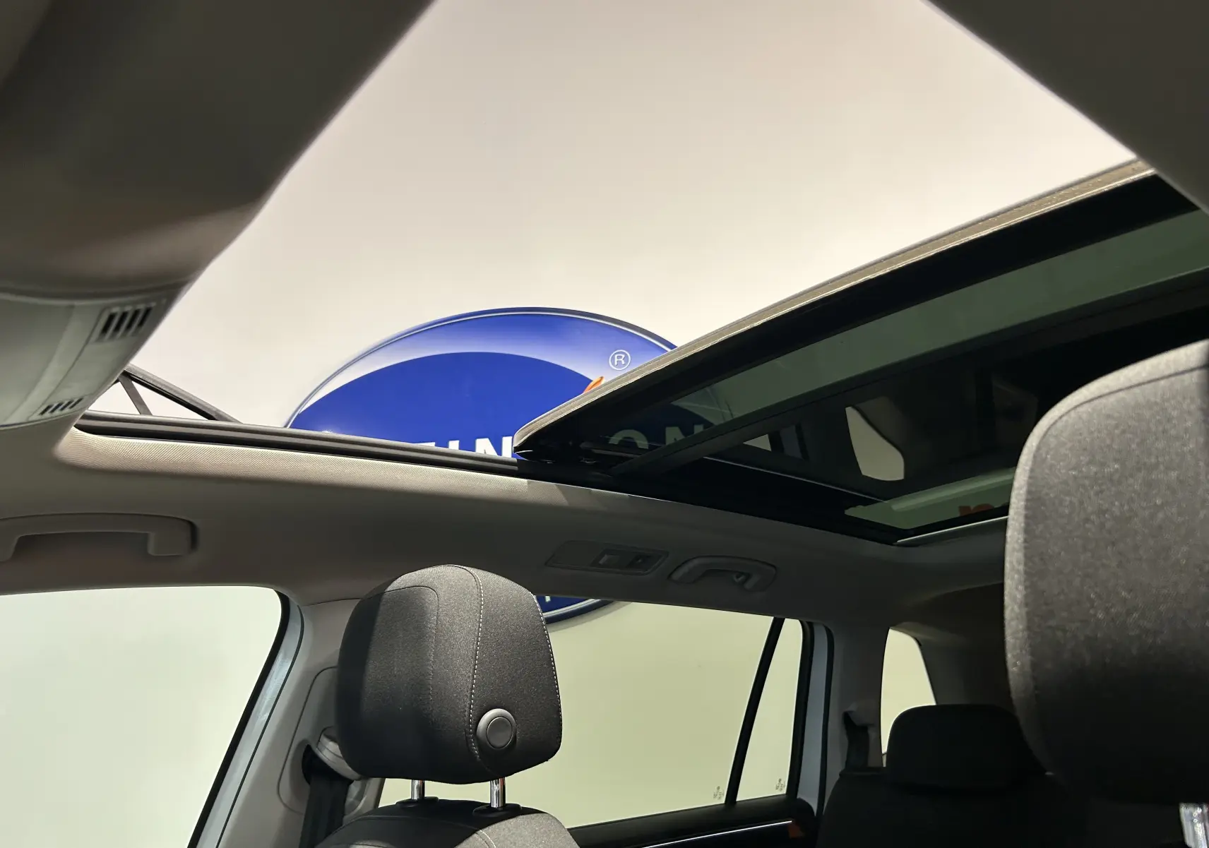 Toit ouvrant panoramique ouvert vu de l'intérieur arrière du Volkswagen Tiguan Allspace blanc de 2018.