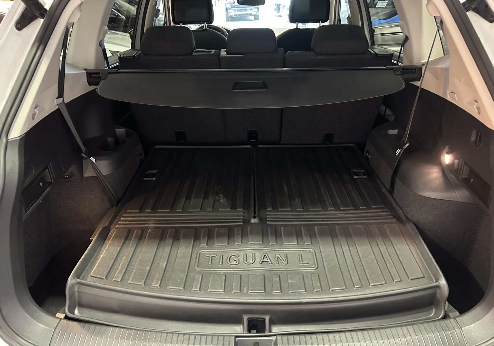 Vue du coffre ouvert du Volkswagen Tiguan Allspace blanc de 2018 avec tapis de coffre Tiguan L en caoutchouc noir.