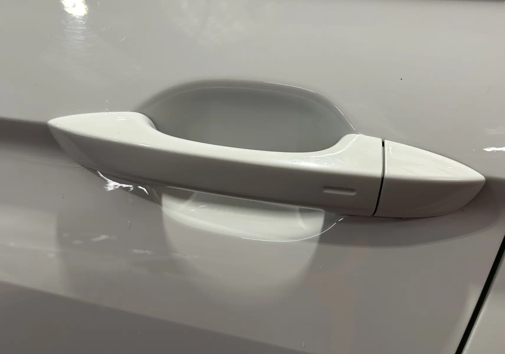 Poignée de porte blanche en gros plan sur le côté gauche d'un Volkswagen Tiguan Allspace 2018.