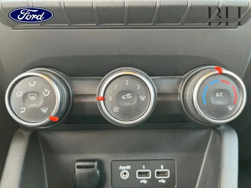 Vue rapprochée des commandes de climatisation et des ports USB d'une Renault Clio gris platine 2019.