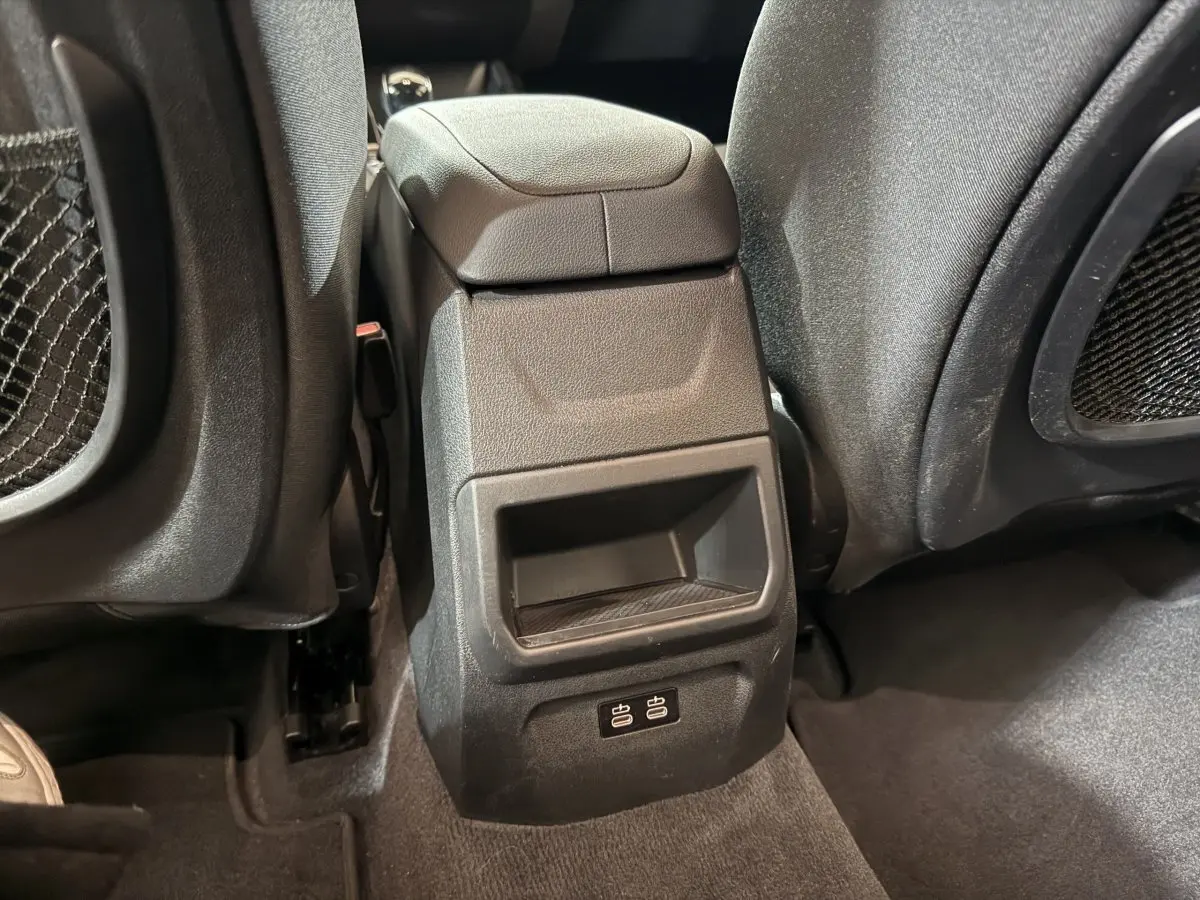 Détail de la console centrale arrière avec ports USB visibles entre les sièges avant d'une BMW Série 1 blanche 2023.