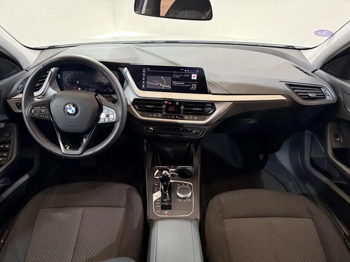Vue intérieure avant du tableau de bord et volant cuir noir de la BMW Série 1 116i Business Design 2023.