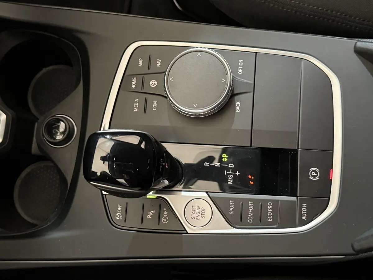 Vue rapprochée de la console centrale noire de la BMW Série 1 116i avec levier de vitesses automatique et commandes de modes de conduite.