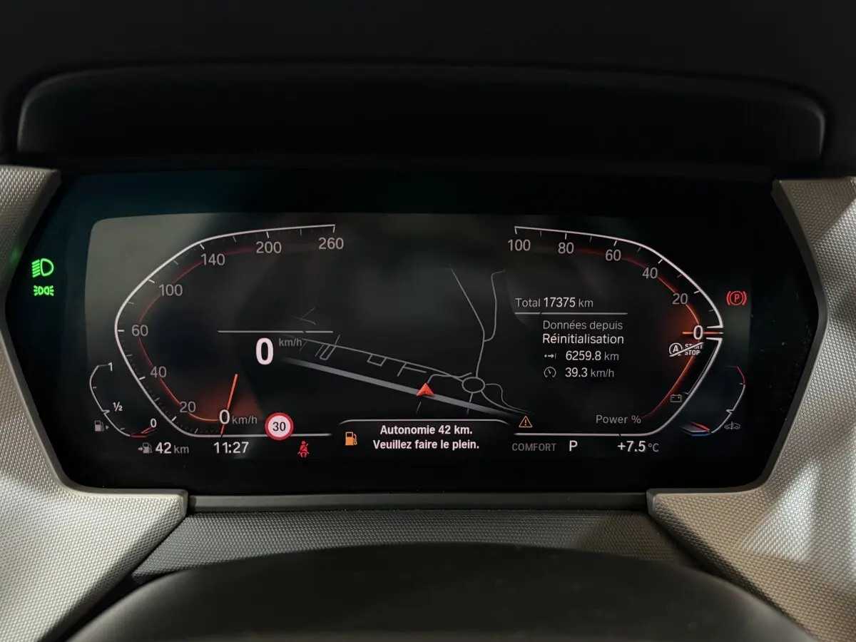 Combiné d'instruments numérique de la BMW Série 1 116i 2023 affichant la vitesse, autonomie et navigation.