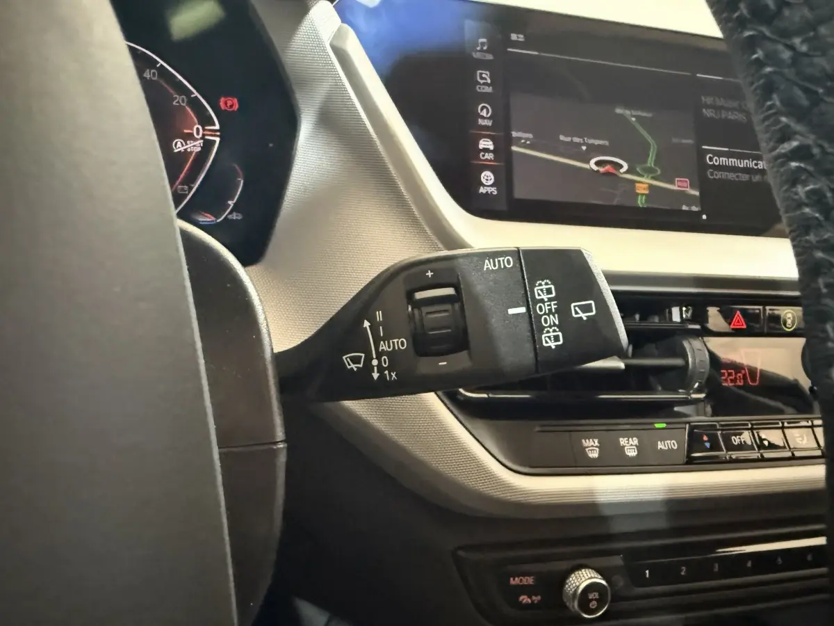 Gros plan sur la commande d'essuie-glace côté gauche du tableau de bord de la BMW Série 1 blanche 116i 2023.