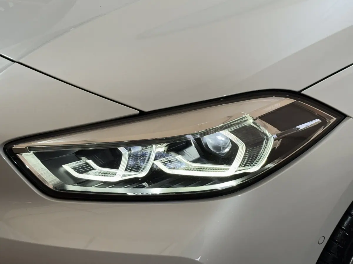 Gros plan sur le phare avant droit LED blanc d'une BMW Série 1 116i Business Design 2023.