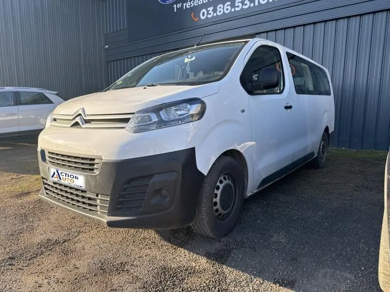 Vue 3/4 avant droit d'un Citroën Jumpy XL blanc Banquise avec pare-chocs noirs et jantes tôles grises.