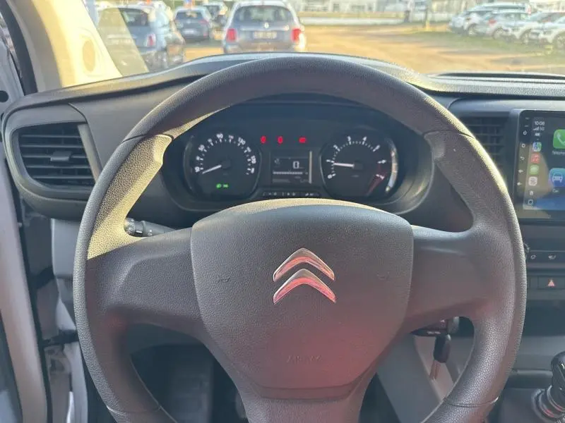 Vue intérieure centrée sur le volant Citroën d'un Jumpy blanc, avec tableau de bord et écran tactile visibles.
