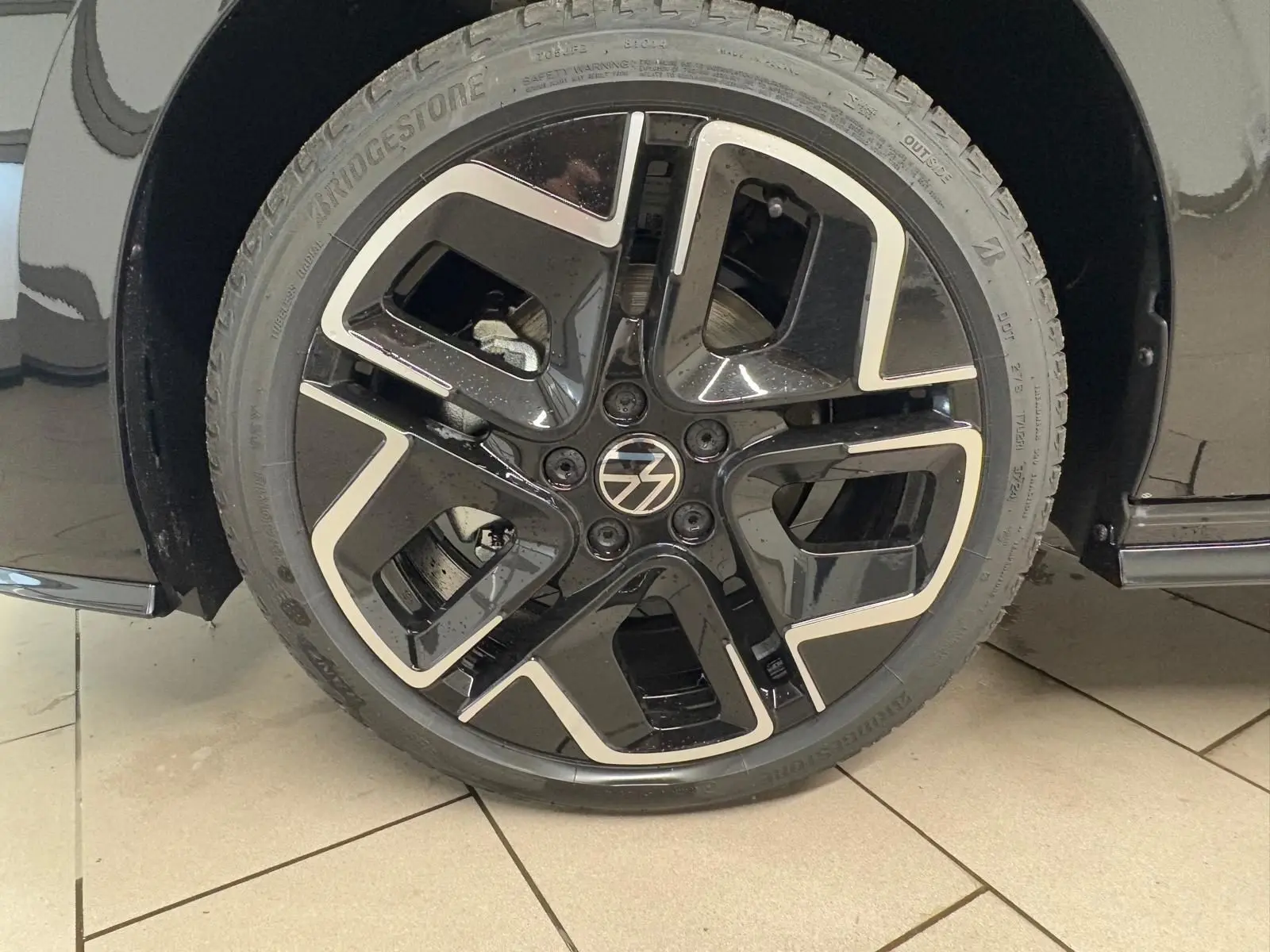 Gros plan sur la roue avant droite noire grenadille d'une Volkswagen Golf 2.0 TDI 150 DSG7 R-Line.