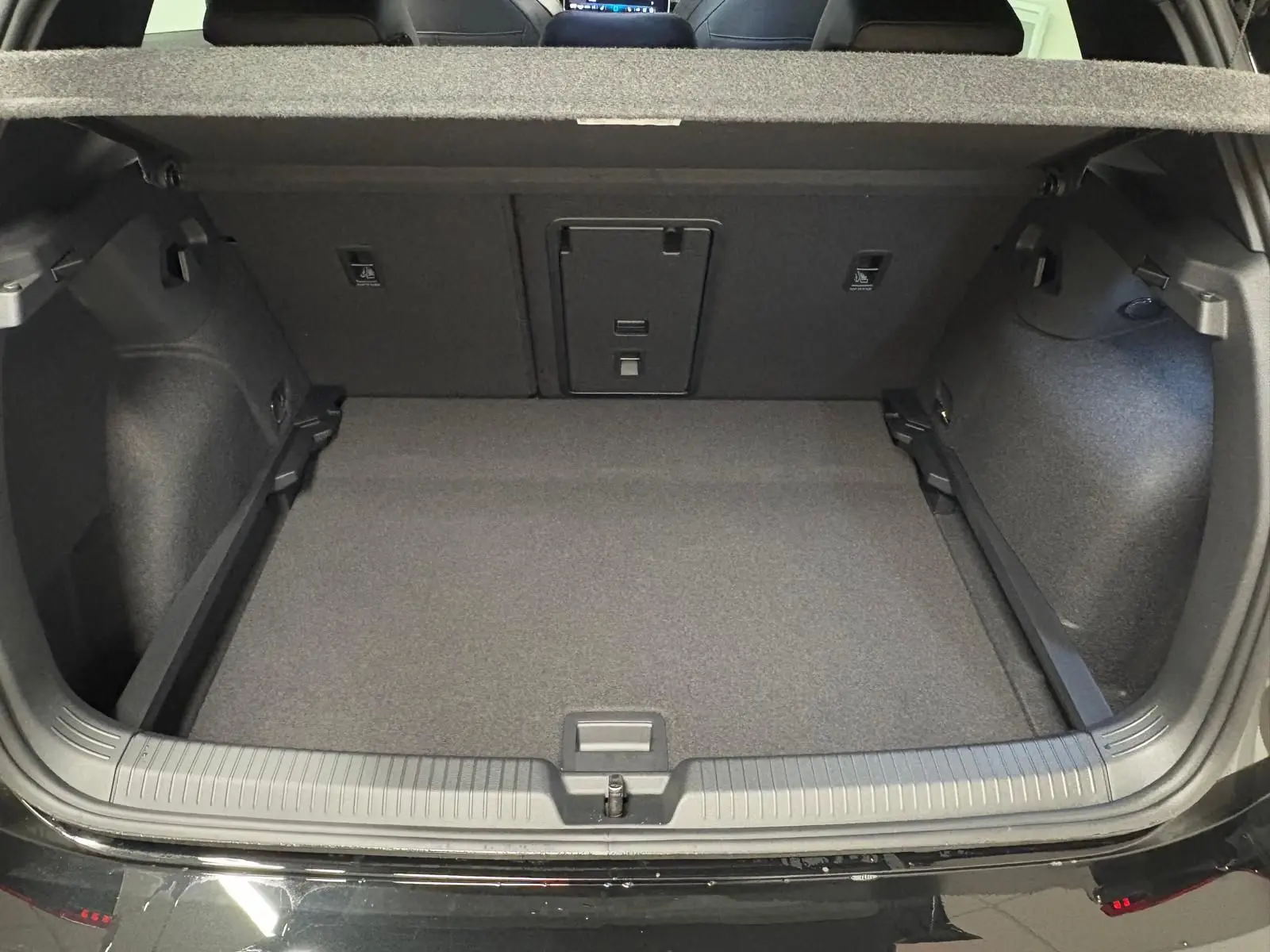 Coffre ouvert vu de l'arrière d'une Volkswagen Golf 2.0 TDI 150 DSG7 R-Line noir grenadille, intérieur de coffre spacieux.