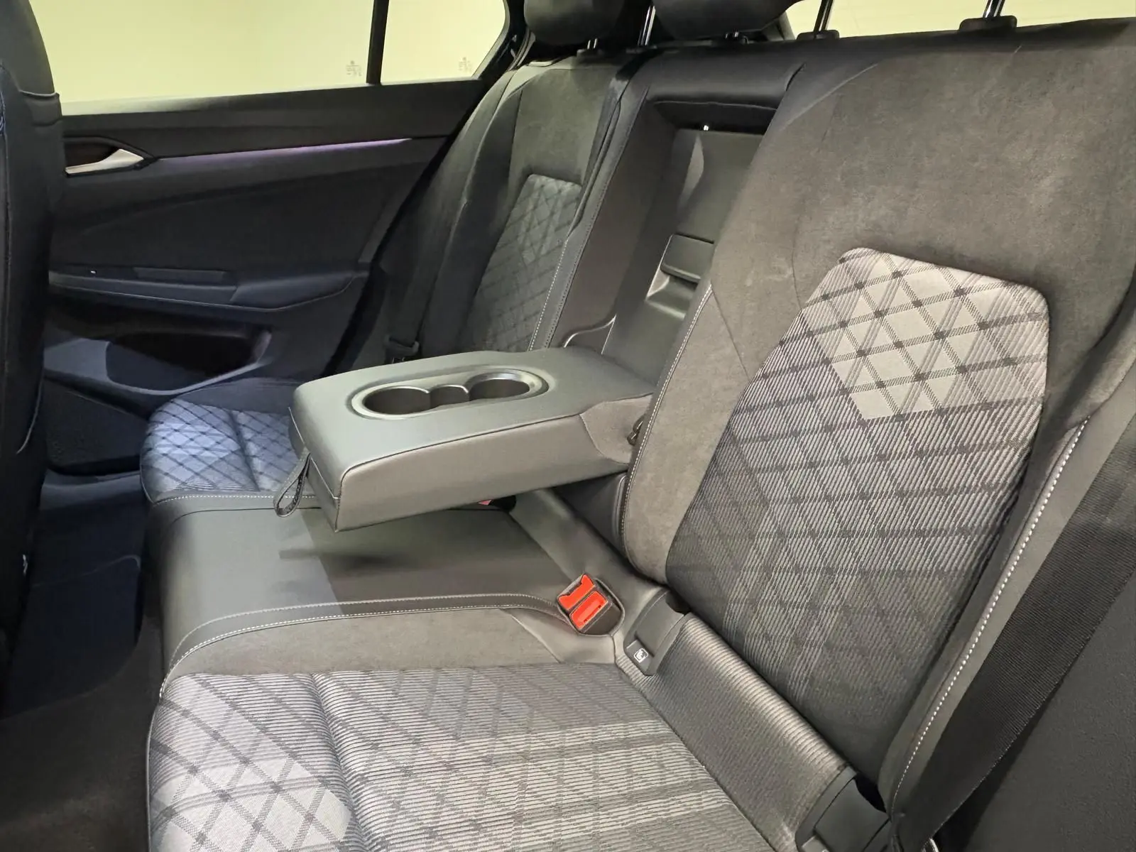 Vue intérieure des sièges arrière de la Volkswagen Golf 2.0 TDI 150 DSG7 R-Line, avec accoudoir central déployé et sellerie noire.