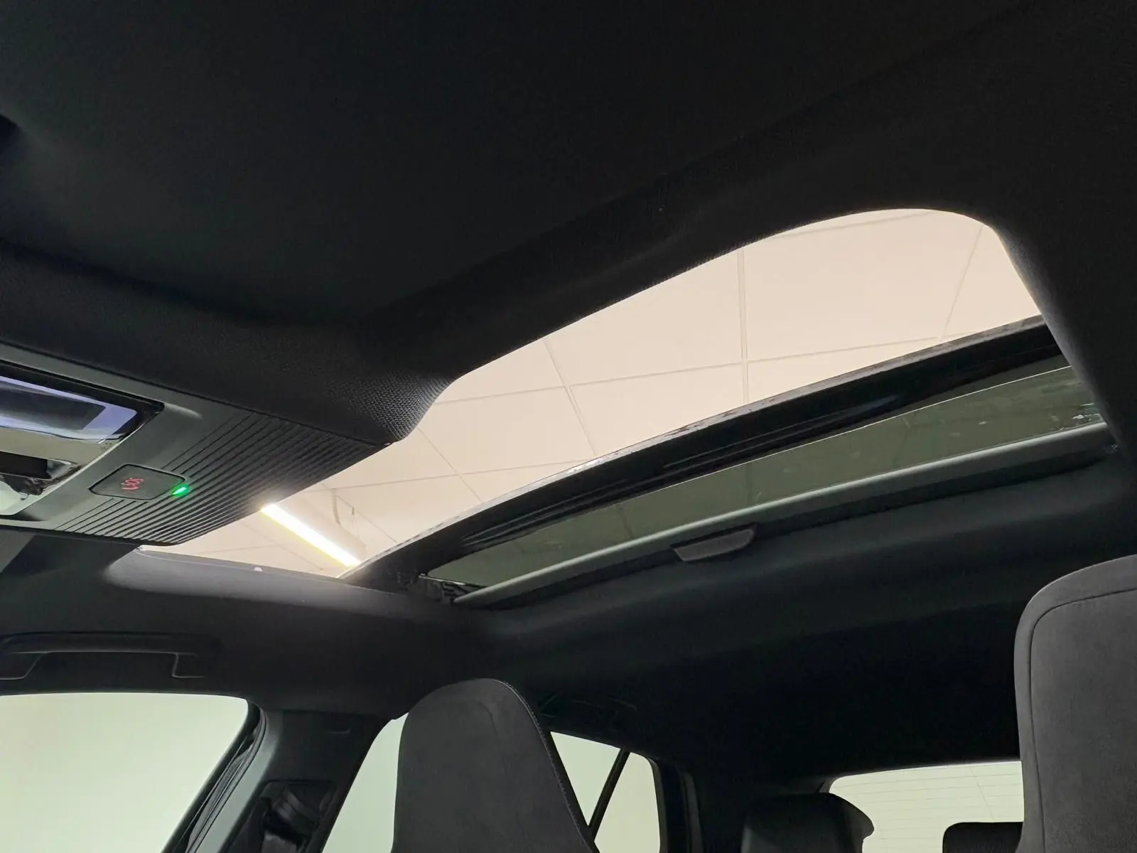 Vue intérieure du toit ouvrant panoramique ouvert sur Volkswagen Golf 2.0 TDI noir Grenadille, mettant en valeur l'habitacle sombre.