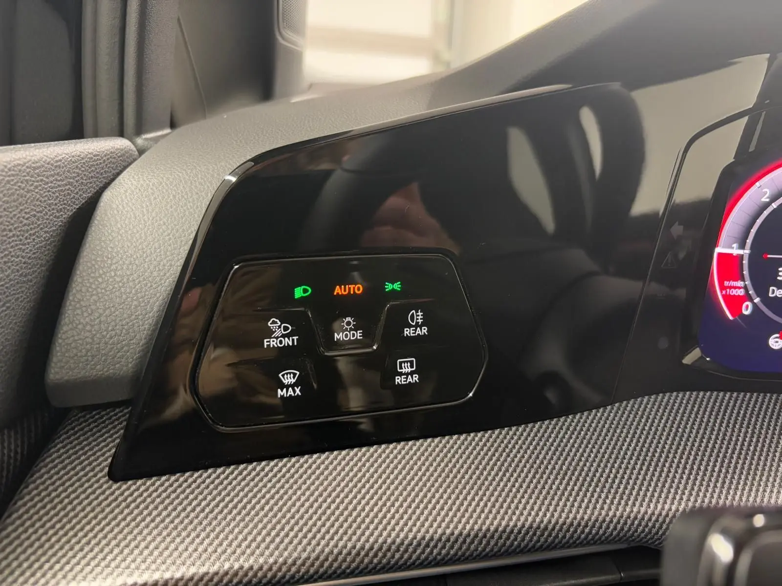 Détail du tableau de bord noir de la Volkswagen Golf 2.0 TDI 150 DSG7 R-Line avec commandes d'éclairage et affichage digital partiel.