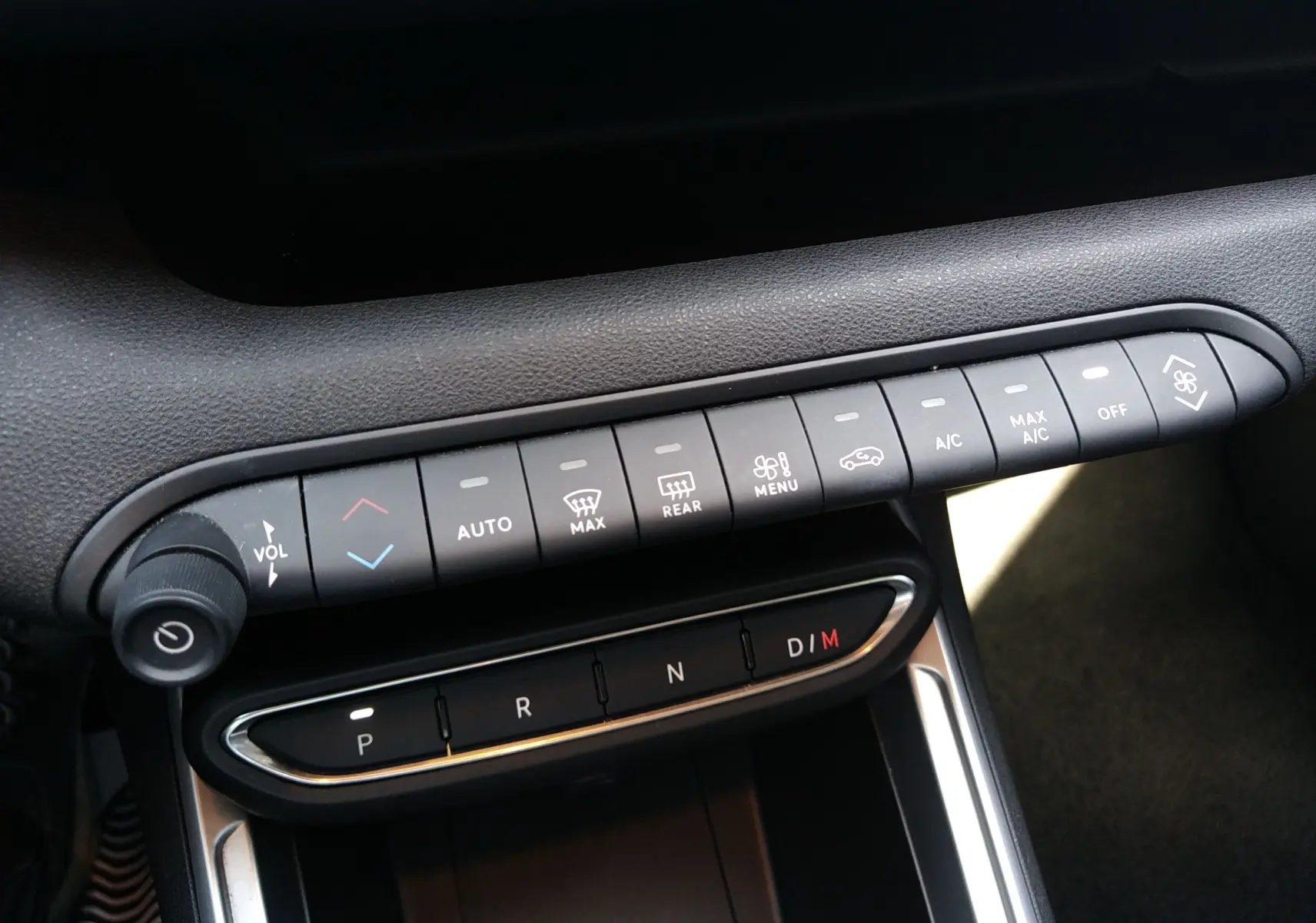 Gros plan sur la console centrale du Jeep Avenger gris, montrant les commandes climatisation et la boîte auto boutons P, R, N, D/M.