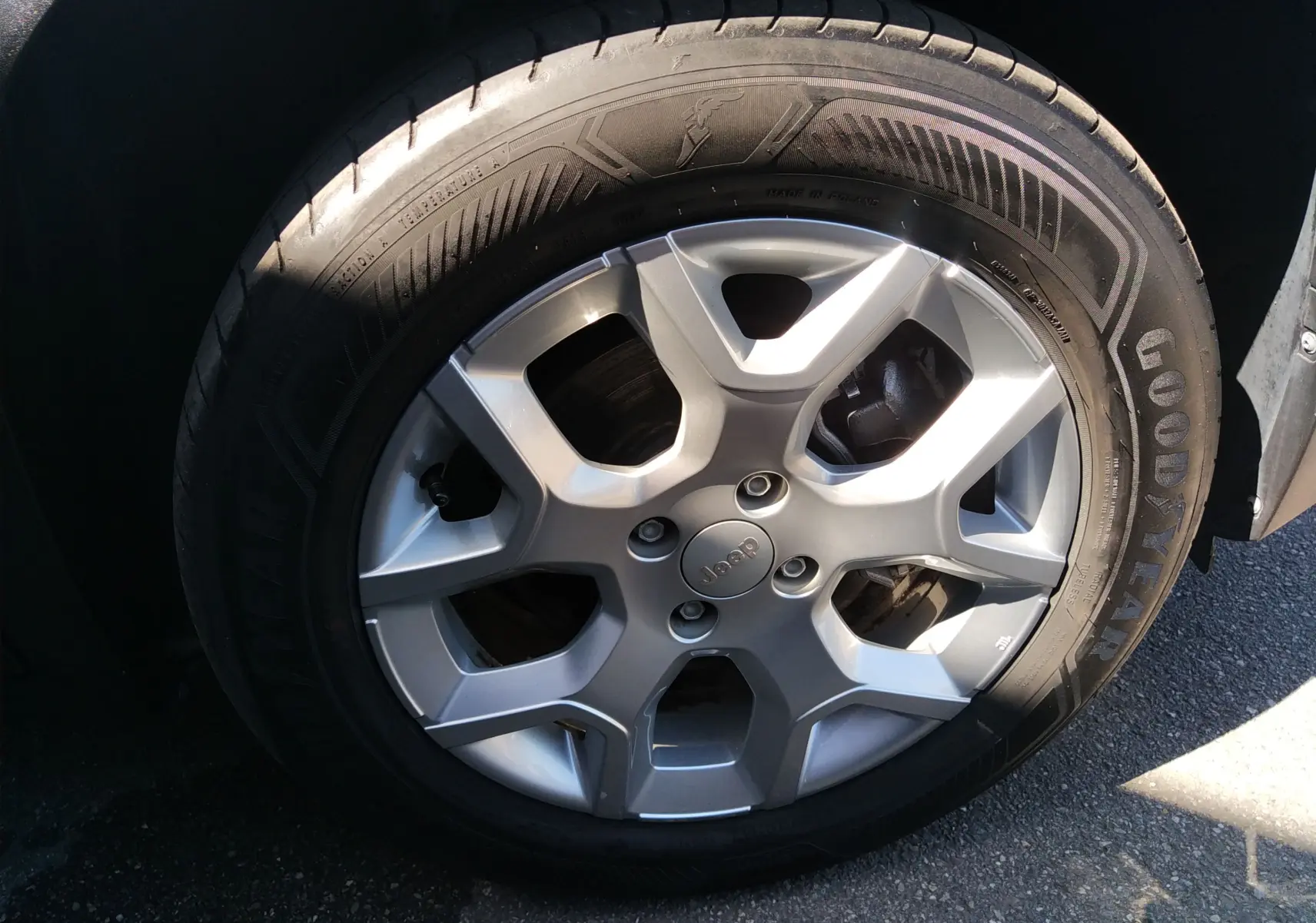 Gros plan sur la jante argentée de la Jeep Avenger eHYBRID 110ch, avec pneu Goodyear visible en lumière naturelle.