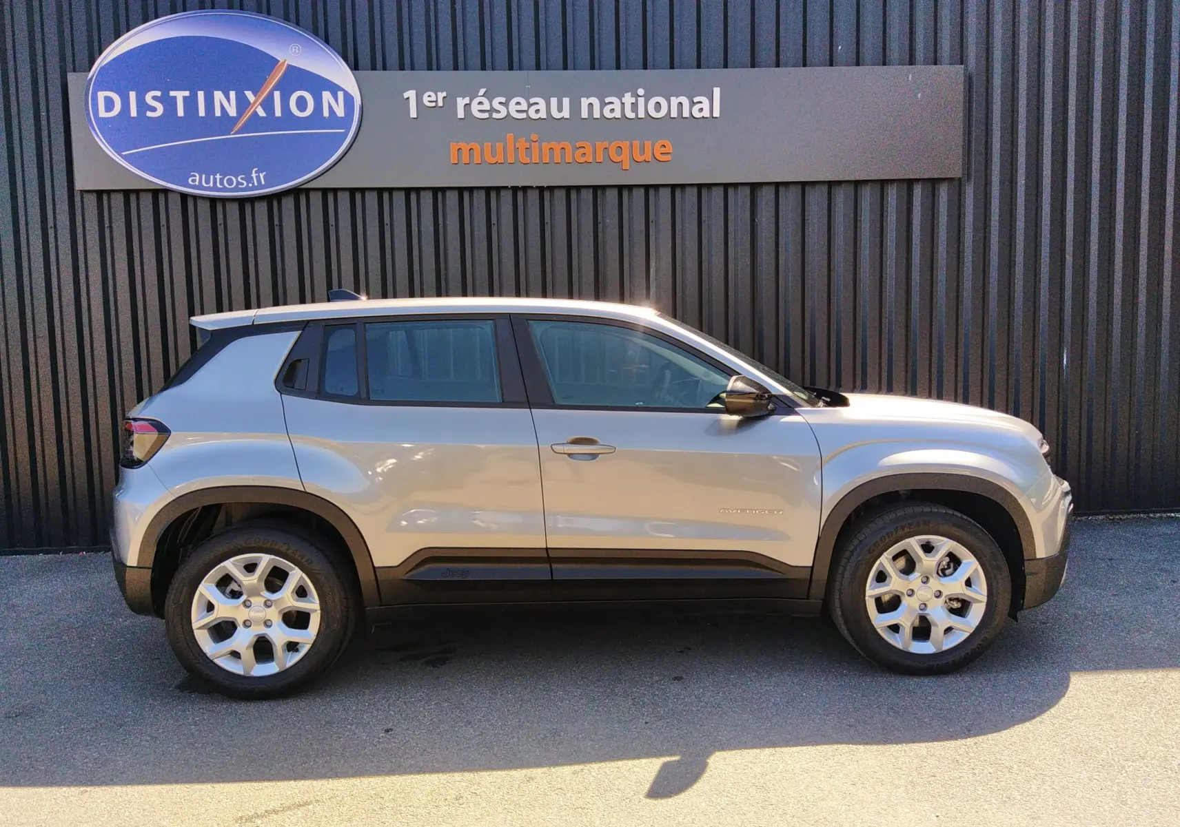 Vue latérale droite d'un Jeep Avenger eHYBRID gris 2025 avec jantes alliage et détails noirs contrastants.