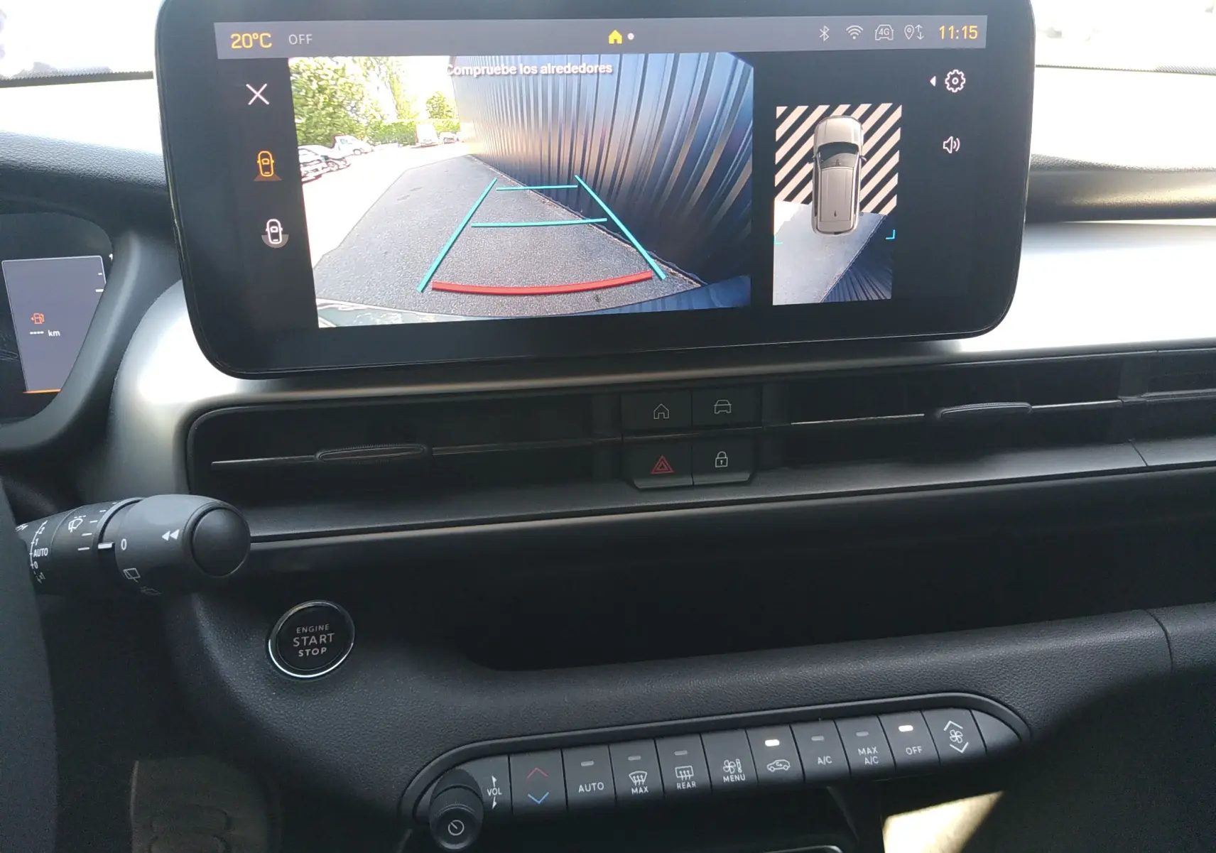 Vue intérieure du tableau de bord du Jeep Avenger gris, écran tactile affichant la caméra de recul et les commandes centrales.