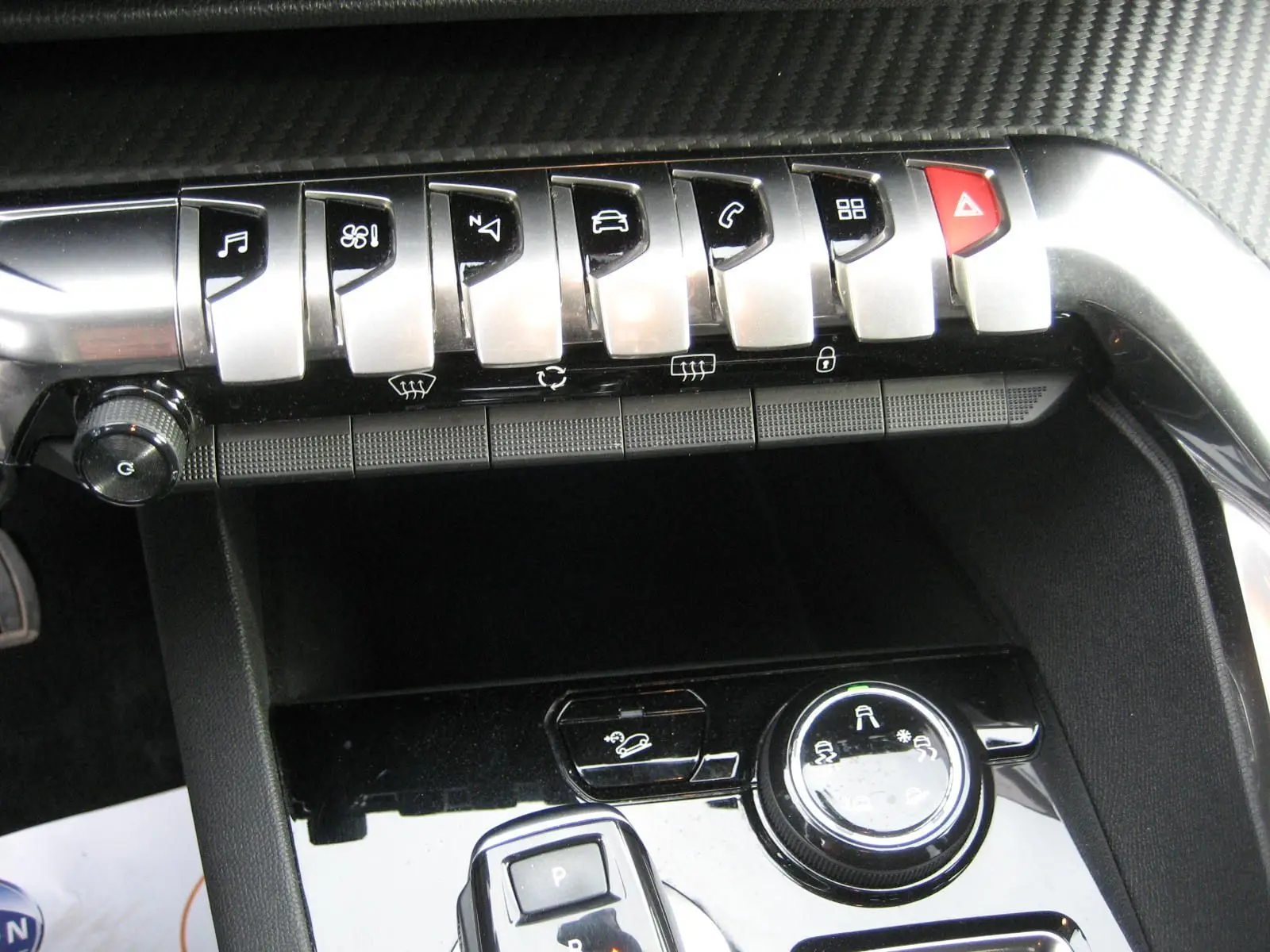 Gros plan sur la console centrale noire du Peugeot 3008 2020 avec boutons de commande et molette de réglage.