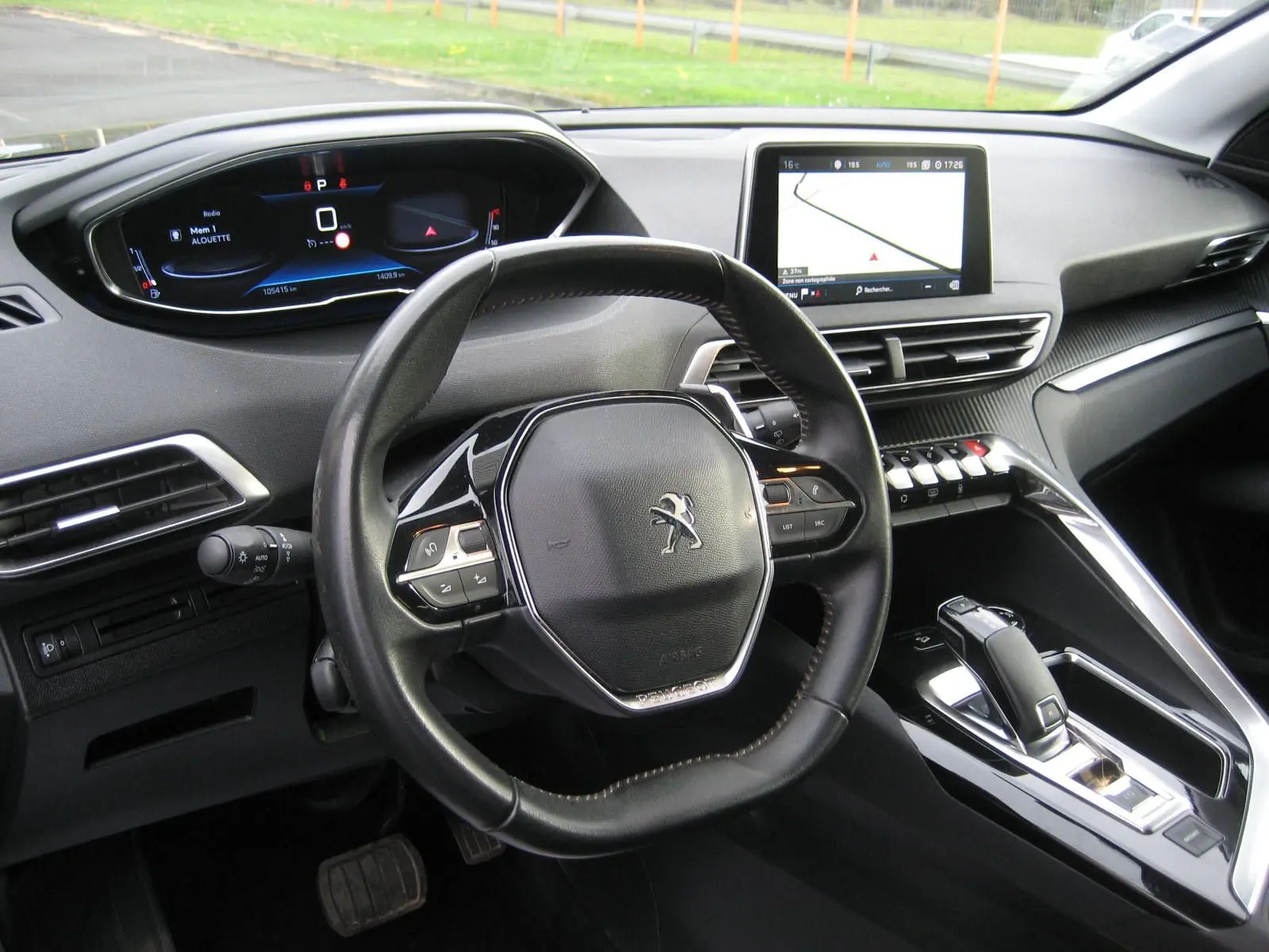 Vue intérieure du poste de conduite du Peugeot 3008 noir, avec volant compact, tableau de bord digital et écran tactile central.