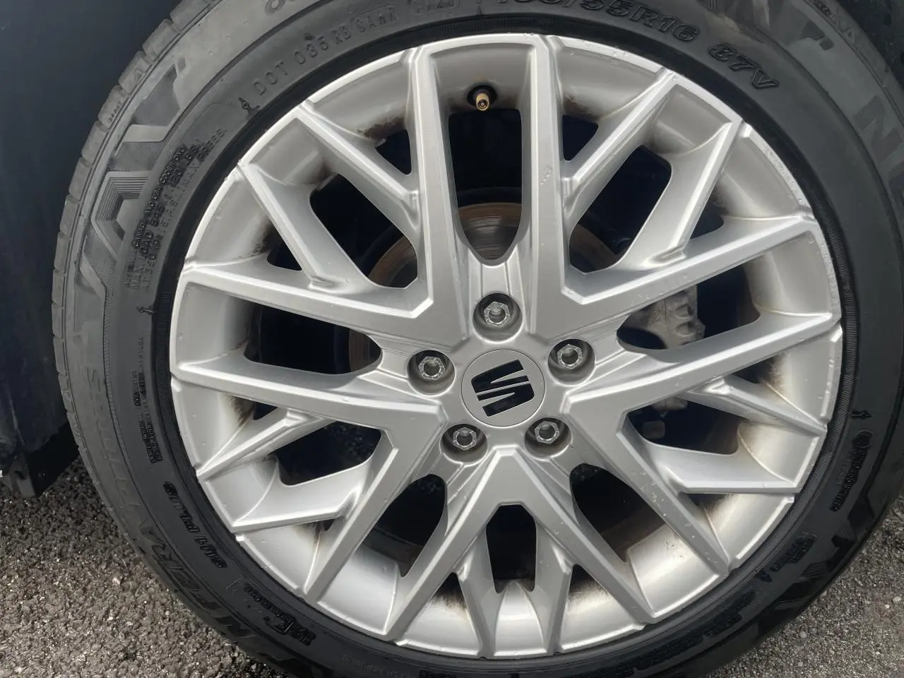 Gros plan sur la jante alliage argentée avec logo SEAT, roue avant d'une SEAT Ibiza blanche 2025.