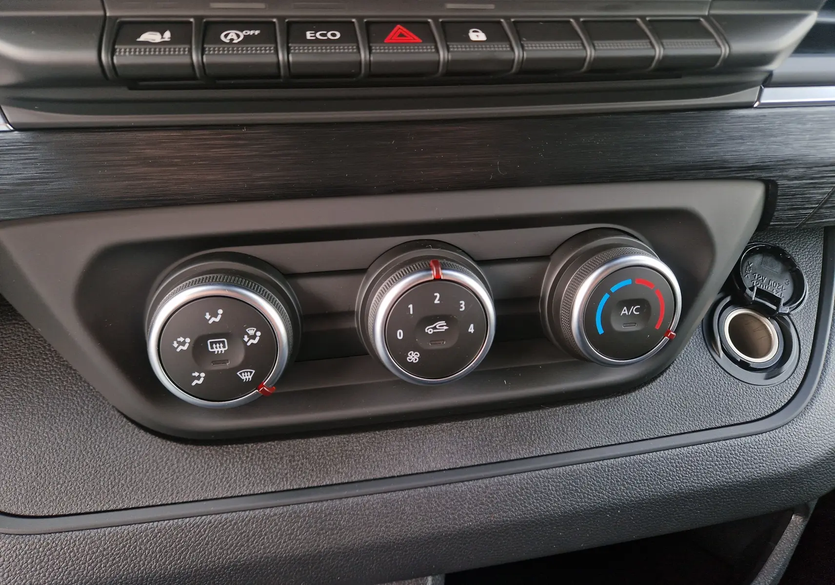 Gros plan sur les commandes de climatisation et ventilation du tableau de bord noir du Nissan Primastar blanc 2025.