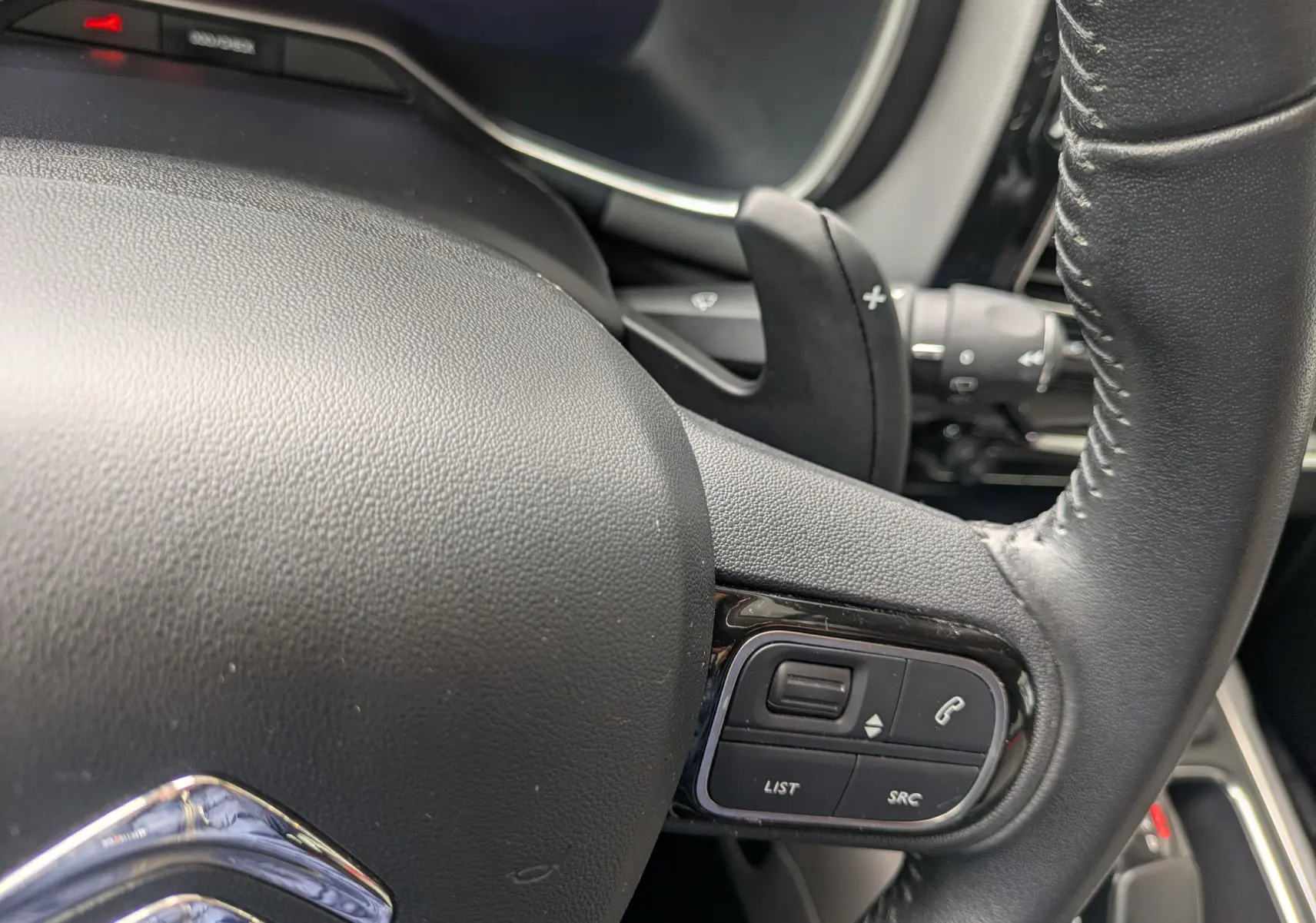 Gros plan sur le volant noir du Citroën C5 Aircross 2020, montrant les commandes audio et téléphone intégrées.