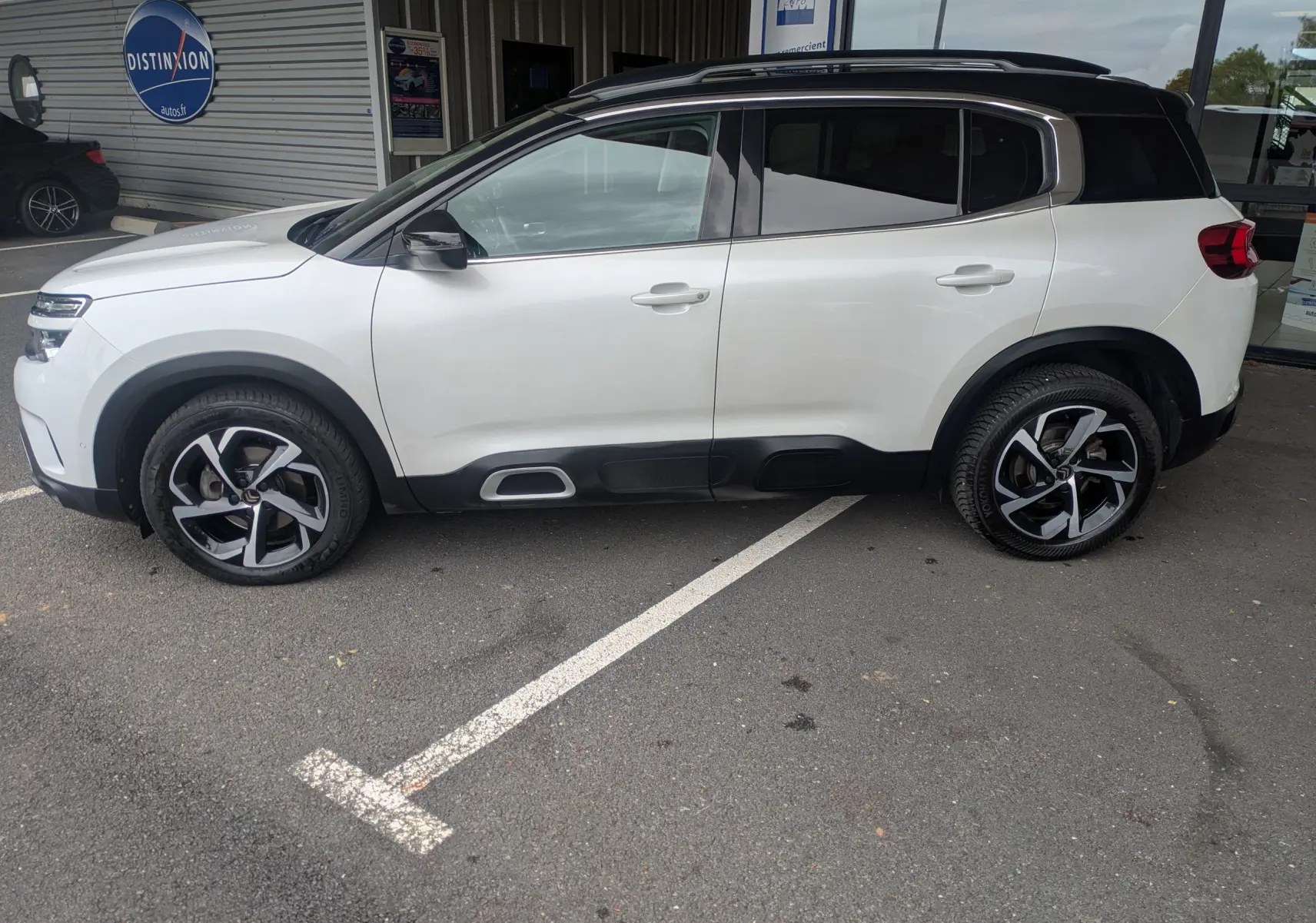 Vue de profil côté gauche d'un Citroën C5 Aircross blanc 2020 avec toit noir et jantes alliage bicolores.