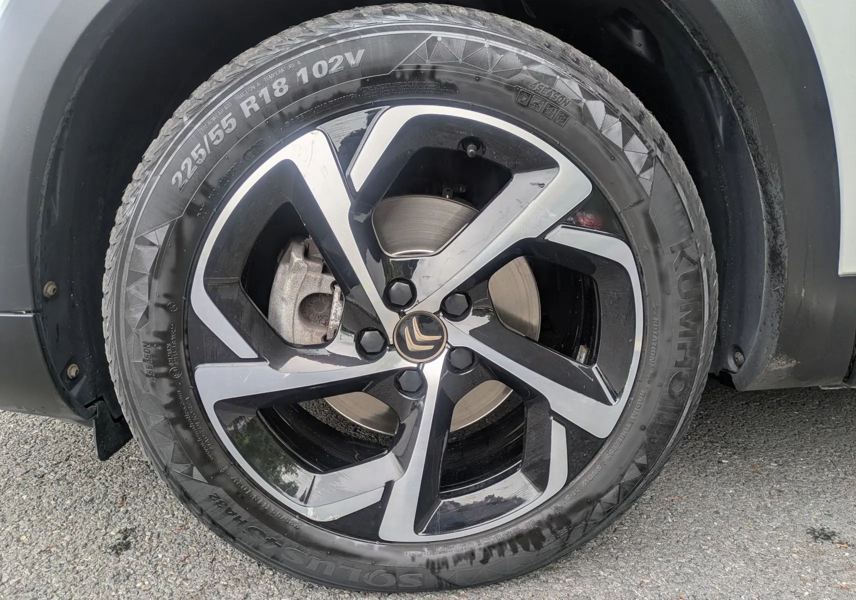 Gros plan sur la roue avant droite d’un Citroën C5 Aircross blanc, mettant en valeur la jante bi-ton noire et argent.