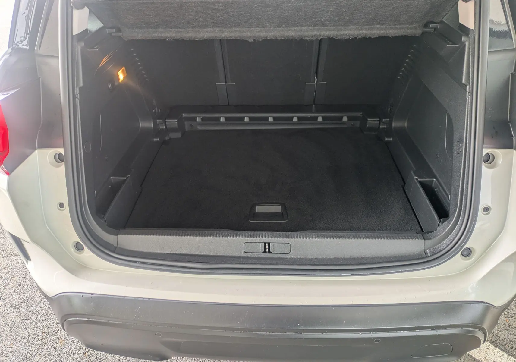 Coffre ouvert vu de l'arrière d'un Citroën C5 Aircross blanc, montrant l'espace de chargement vide et l'éclairage intérieur allumé.