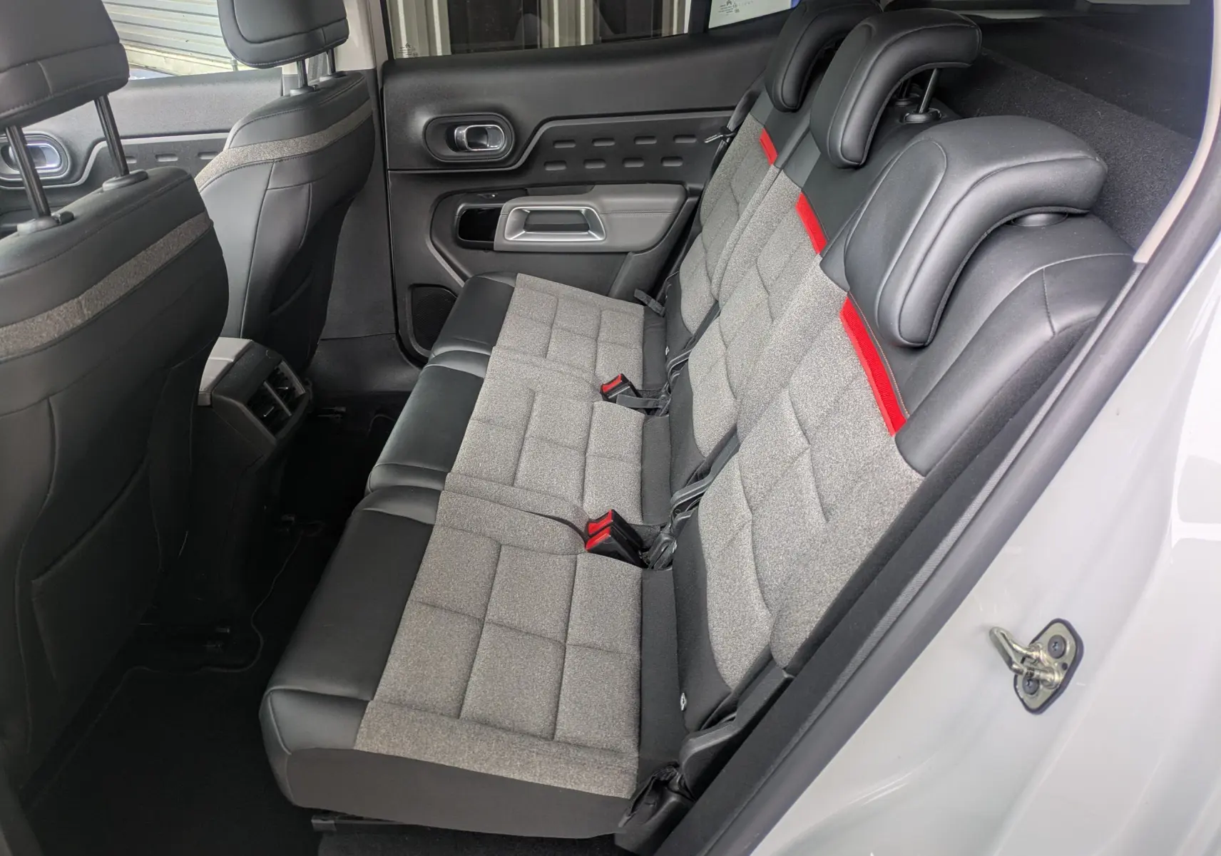 Vue intérieure côté droit des sièges arrière gris et noirs avec surpiqûres rouges du Citroën C5 Aircross blanc 2020.