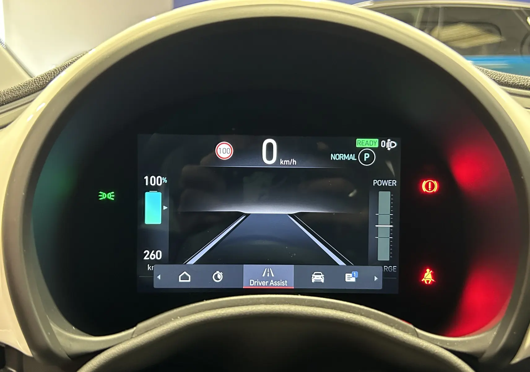 Vue rapprochée du tableau de bord numérique de la Fiat 500 électrique blanche, affichant la vitesse et l'assistance au conducteur.