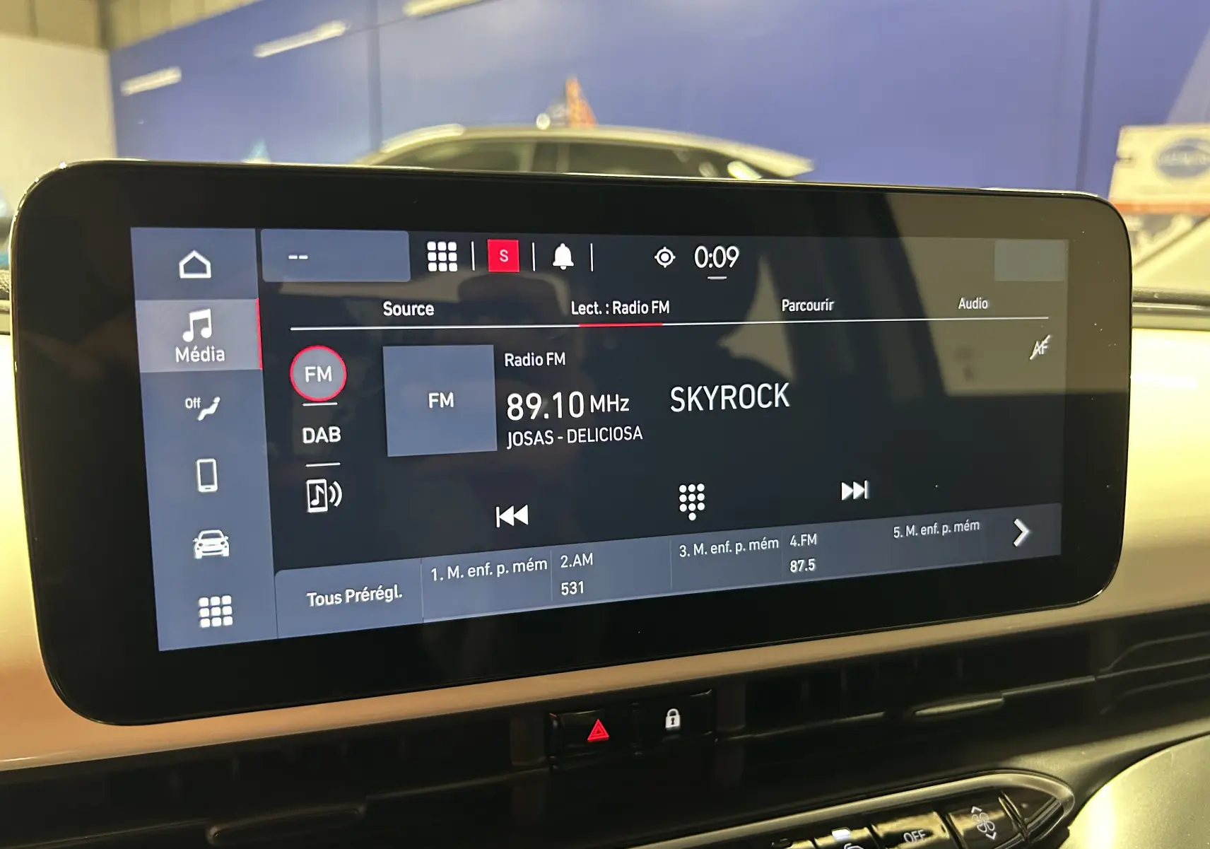 Écran tactile central de la FIAT 500 électrique 2023 affichant la radio FM sur Skyrock, vue intérieure frontale.