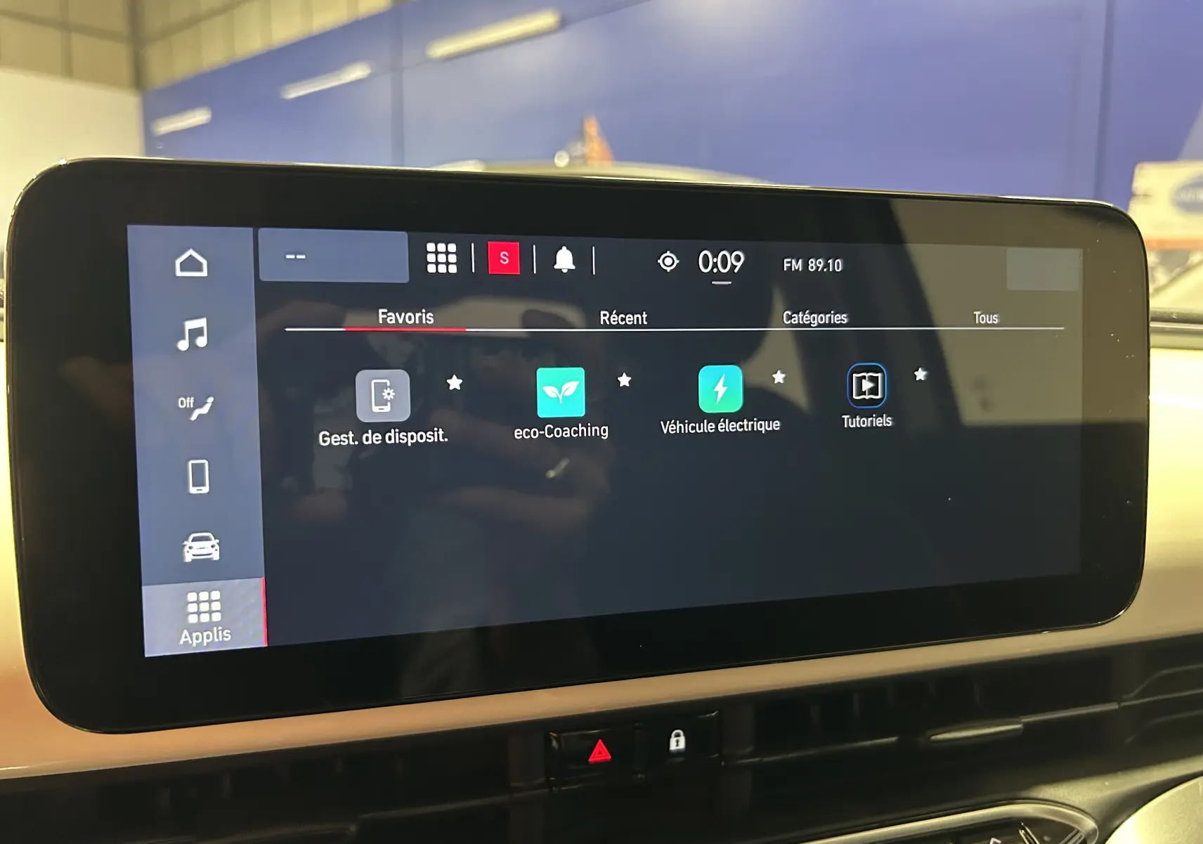 Écran tactile central de la Fiat 500 électrique 2023 affichant les applications de gestion et éco-coaching, vue intérieure.