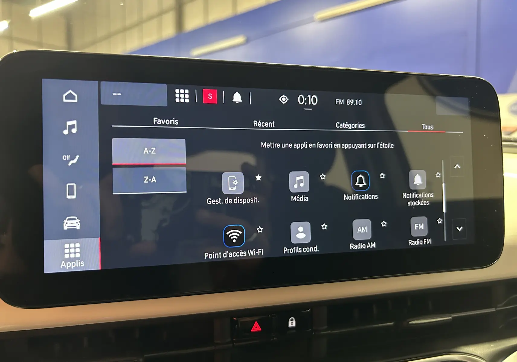 Écran tactile central de la Fiat 500 électrique 2023 affichant le menu des applications avec options Wi-Fi et radio FM.
