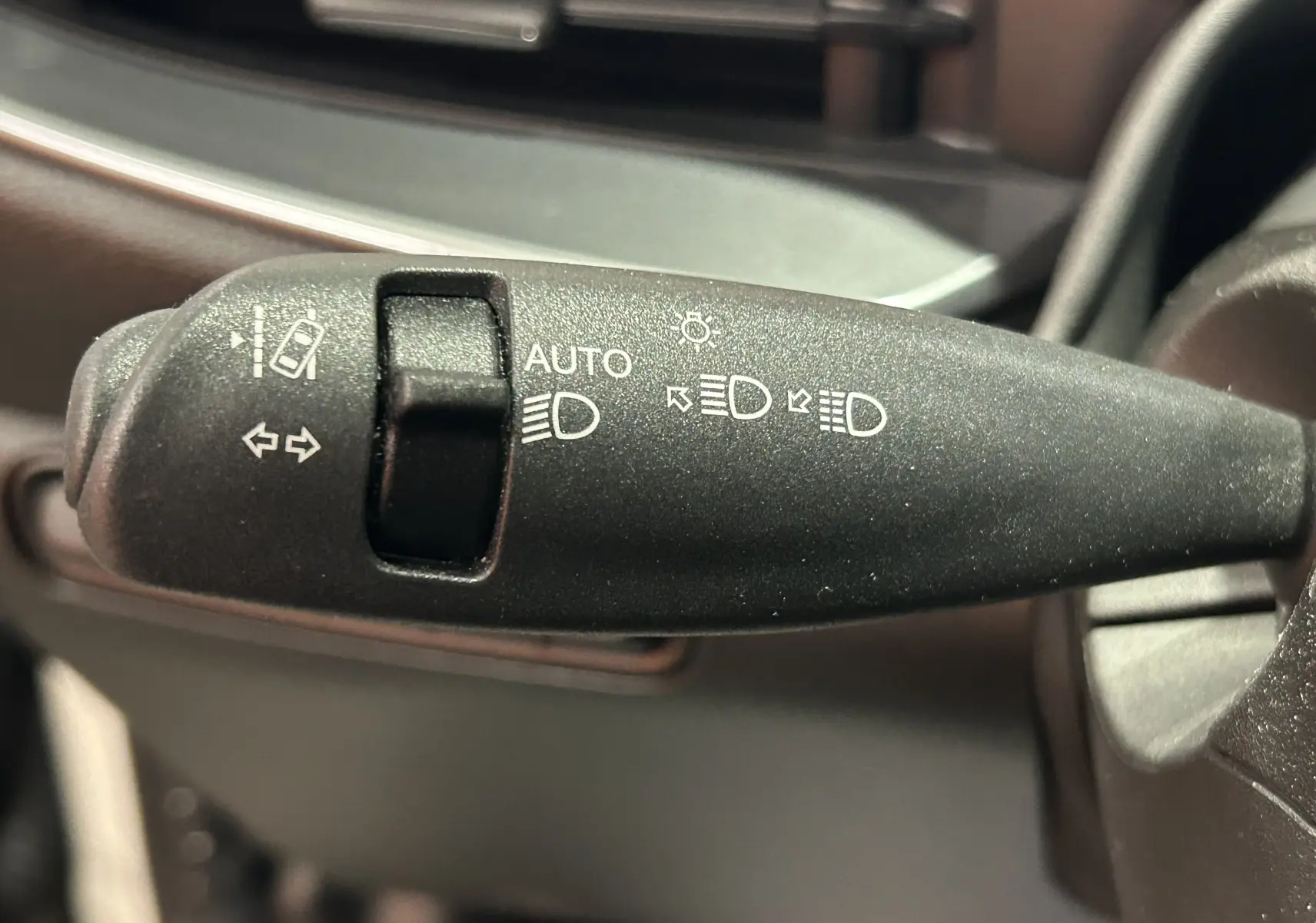 Gros plan sur la commande de feux et clignotants noire à l'intérieur de la Fiat 500 électrique 2023.