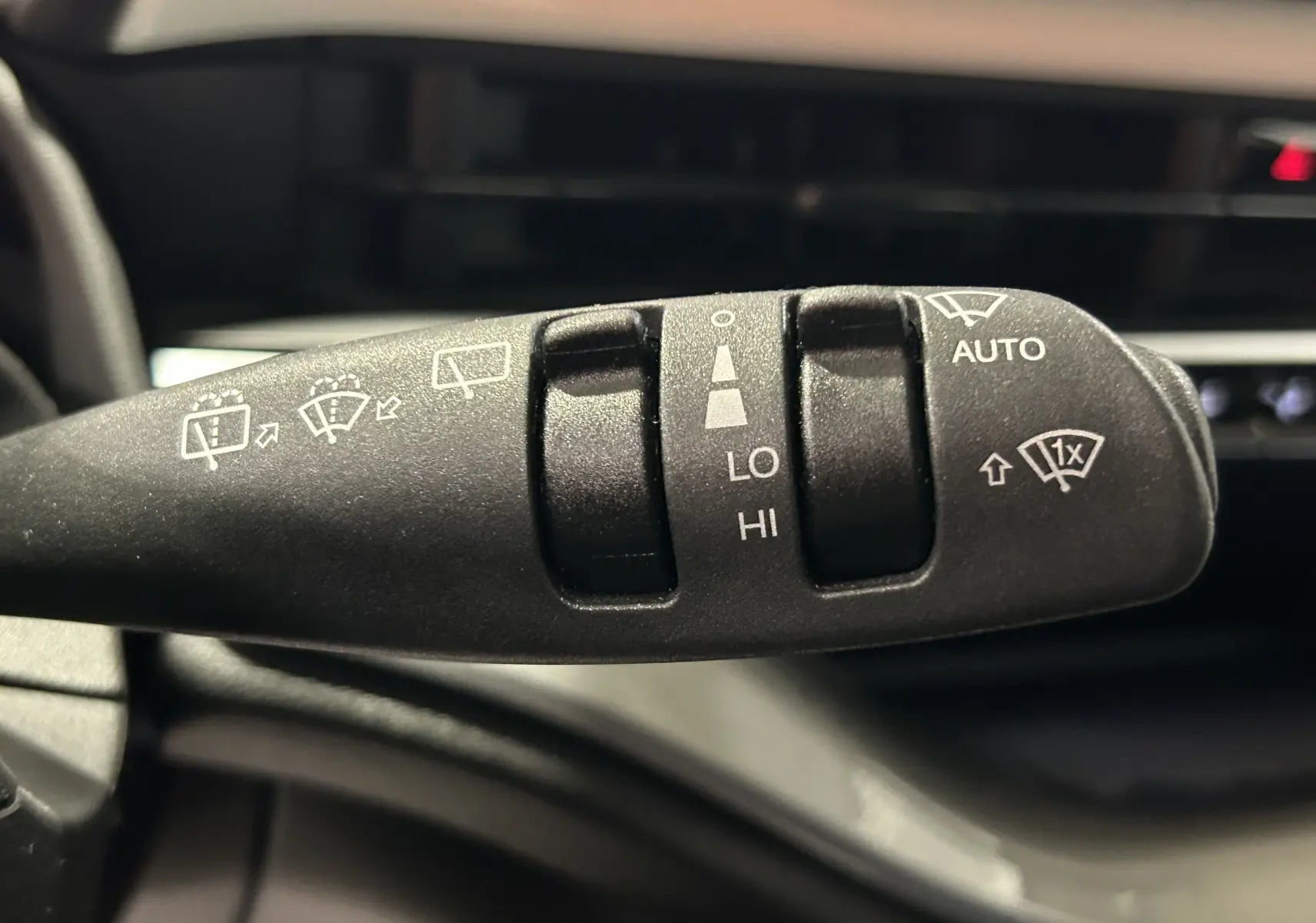 Gros plan sur la commande de l'essuie-glace intérieur d'une Fiat 500 électrique 2023, détails des fonctions visibles.