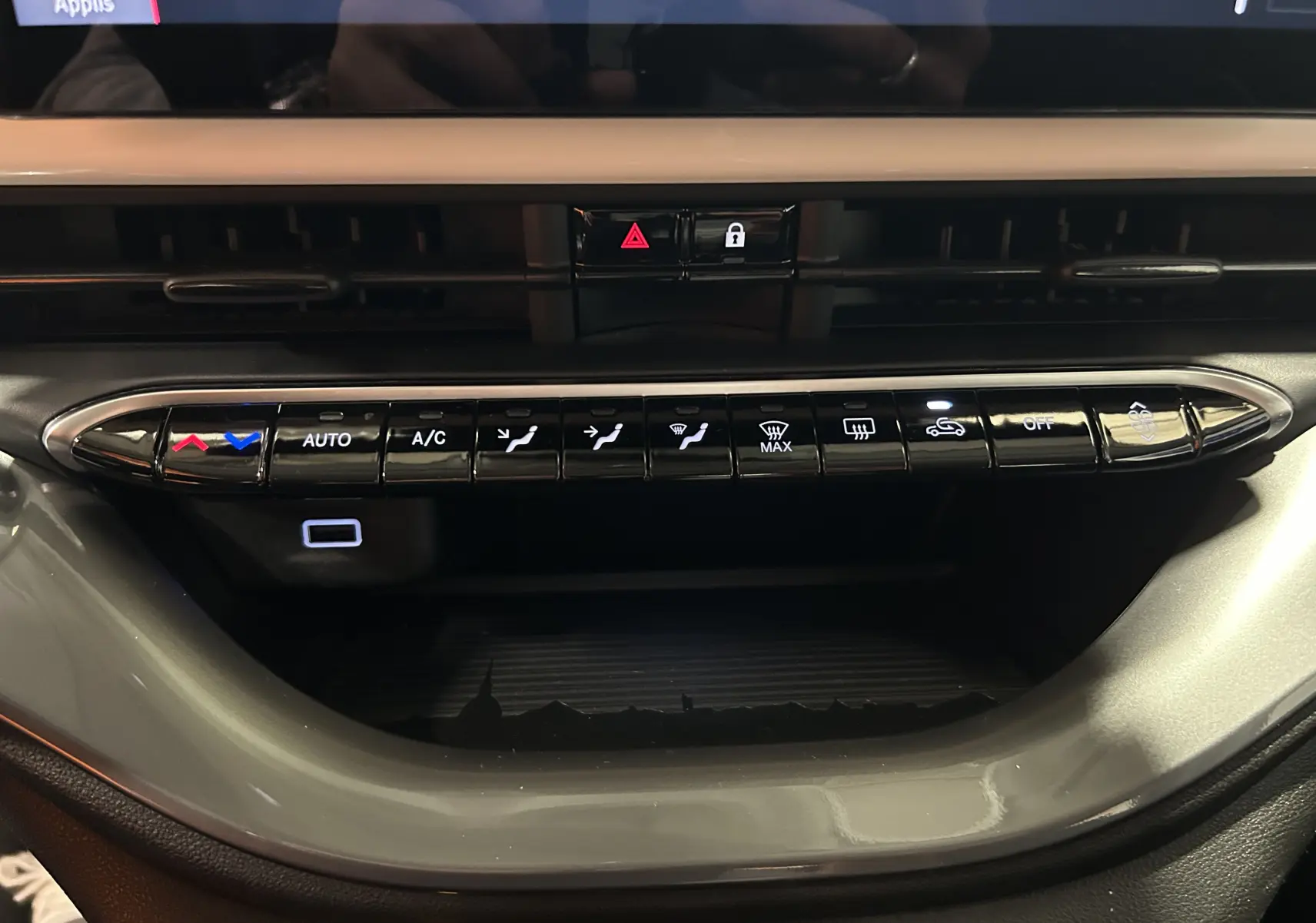 Détail de la console centrale de la FIAT 500 électrique 2023, montrant les commandes de climatisation et ventilation en noir brillant.