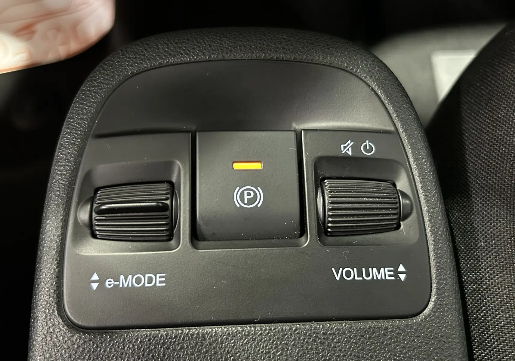 Gros plan sur les commandes centrales noires de la Fiat 500 électrique 2023, avec réglages e-MODE et volume.