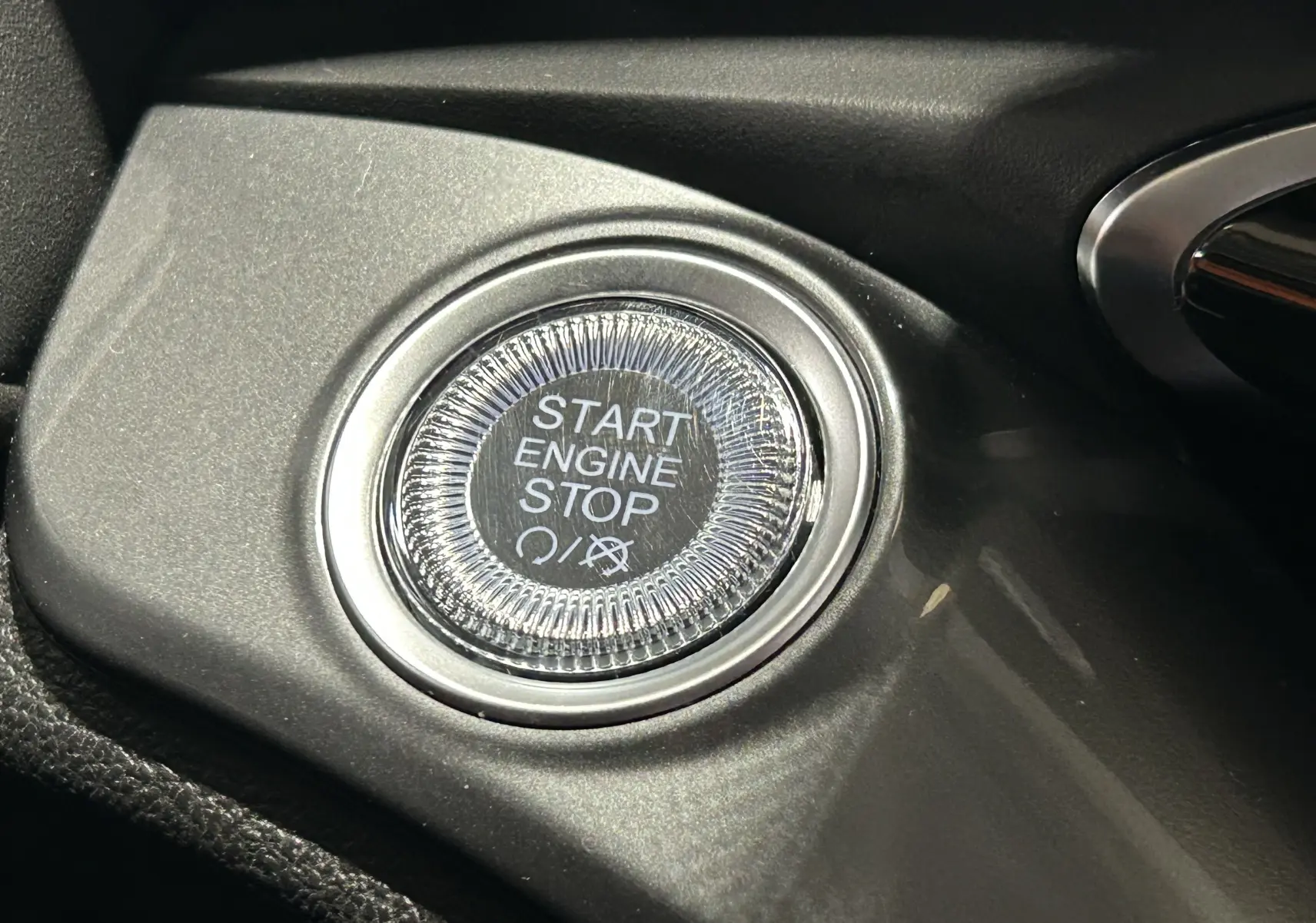 Gros plan sur le bouton Start Engine Stop du tableau de bord noir de la FIAT 500 électrique blanche 2023.