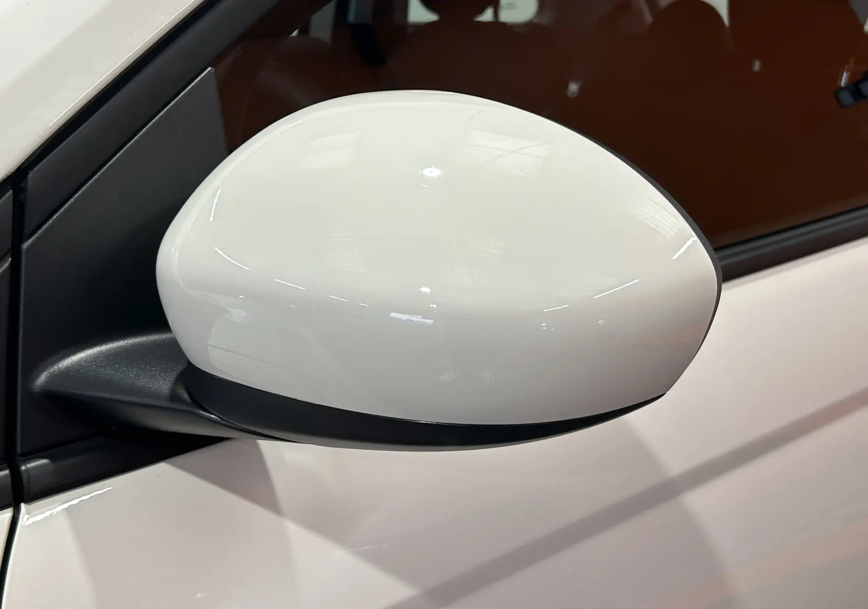 Rétroviseur côté gauche blanc brillant de la FIAT 500 électrique 2023, avec partie inférieure noire mate.