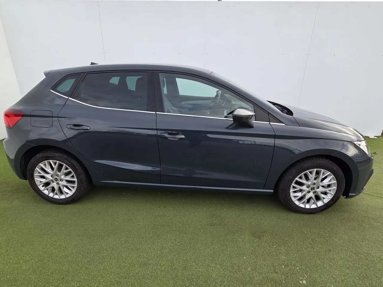 Profil côté gauche d'une SEAT IBIZA 2025 bleu fjord métal avec jantes alliage et vitres teintées arrière.