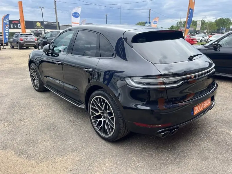Vue 3/4 arrière droite d'un Porsche Macan noir 2018 avec jantes sport et feux arrière LED teintés.